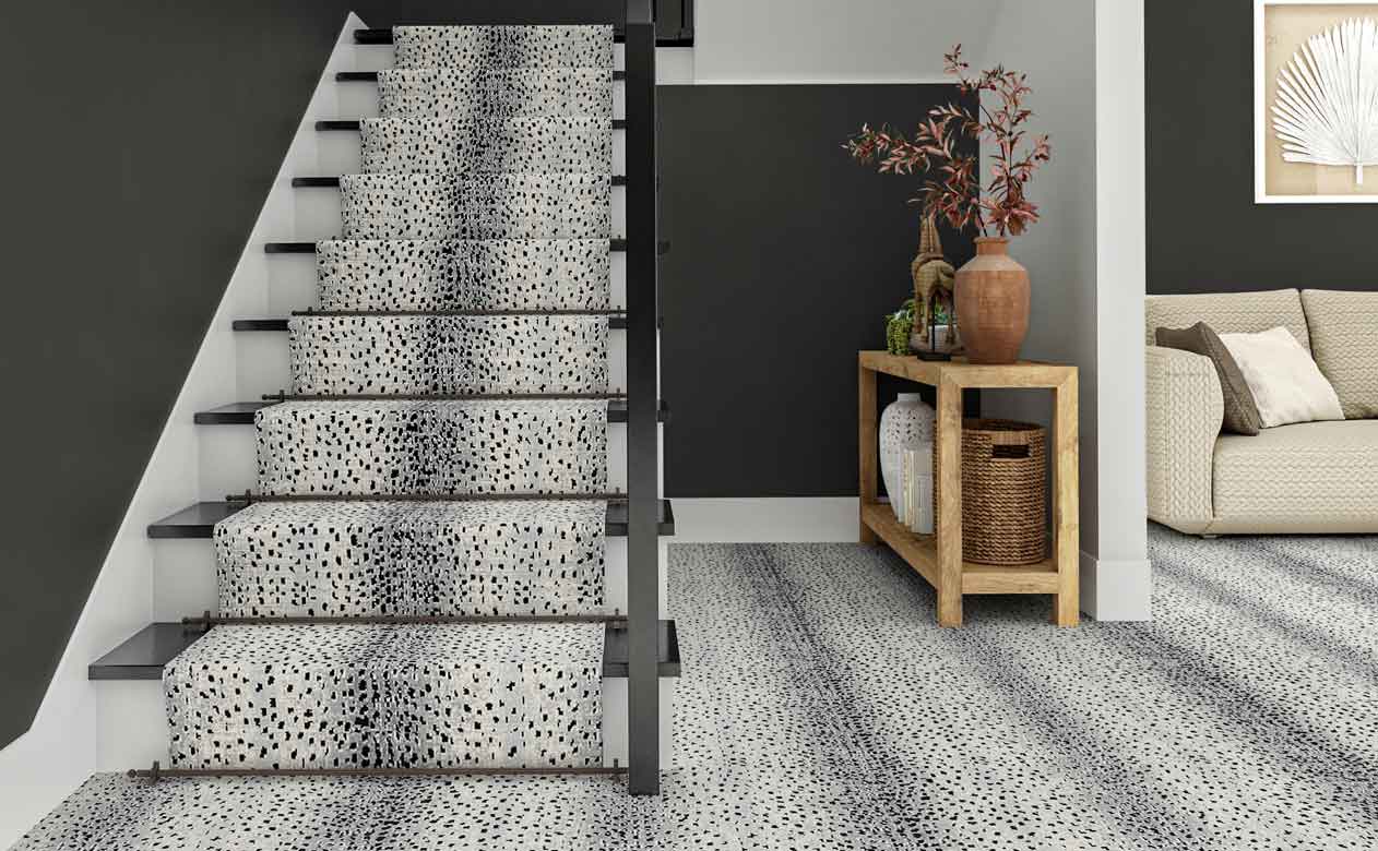 soft gray animal print carpet in entryway with staircase and wood entryway table